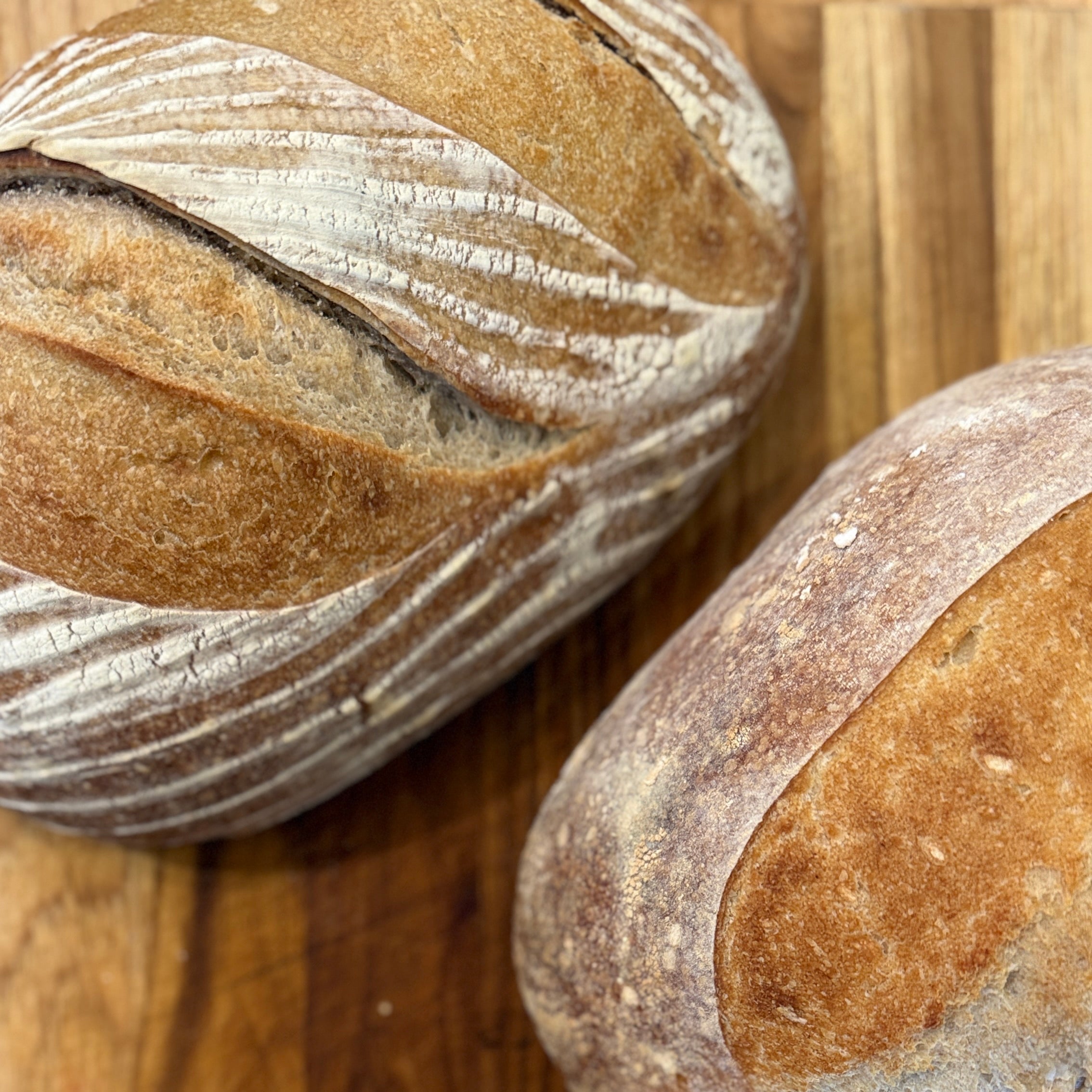 Three loaves of bread on a wooden surface
