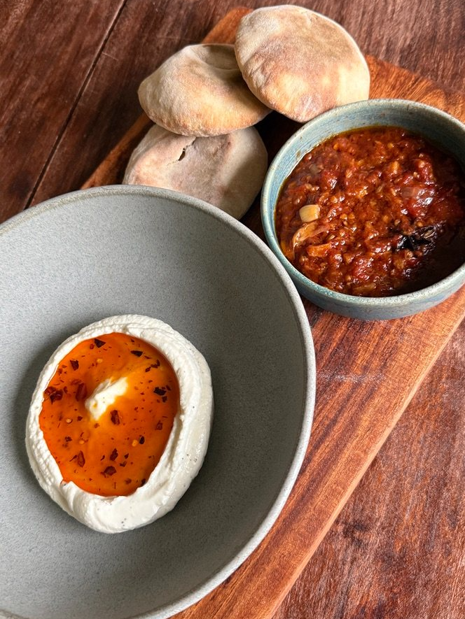 Whipped feta with chili oil, matbucha, and pita